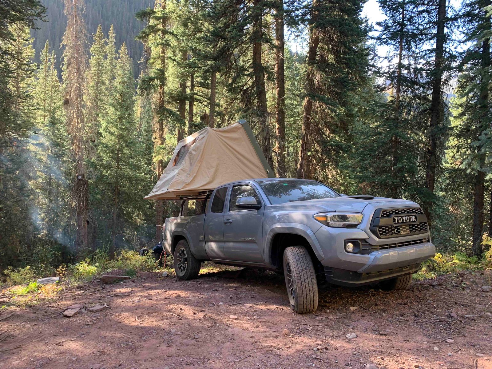 Truck with rooftop tent mounted in the forest